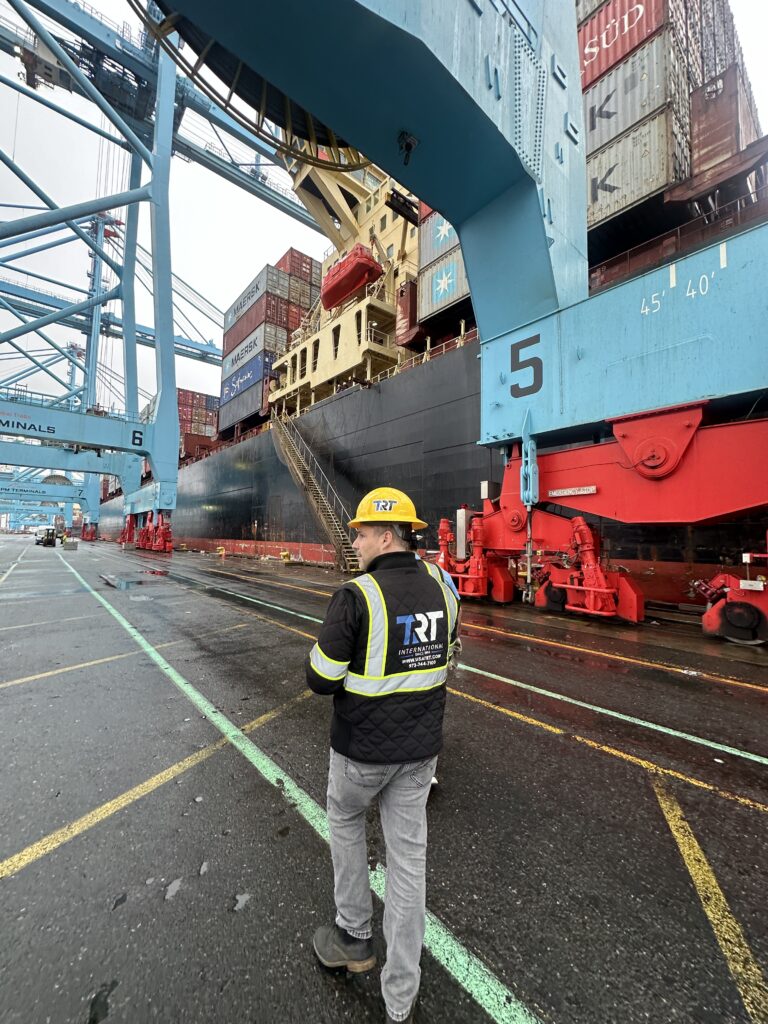 TRT worker in a safety vest watching container operations at the port terminal