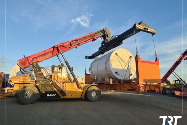 Overweight and distressed load handling — reach stackers loading a cylindrical tank onto a trailer